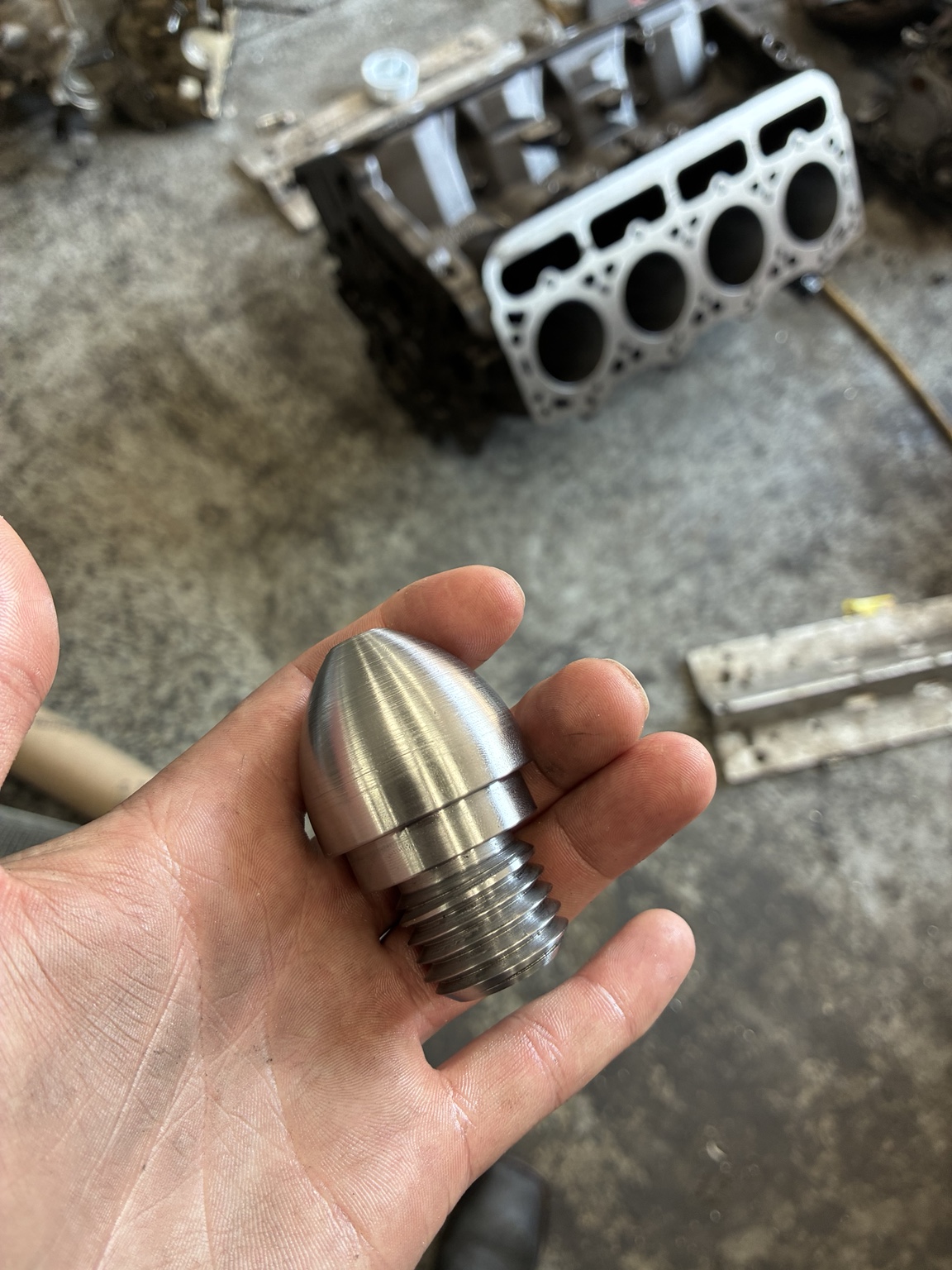 1018 steel component with a rounded profile and external threads